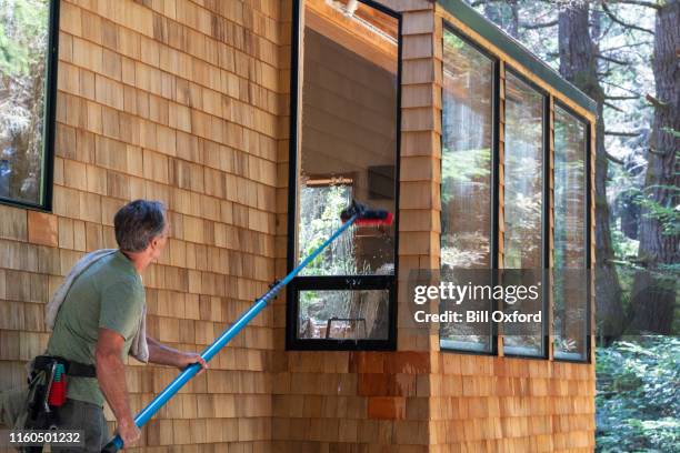 man washing window with long pole and brush - pole stock pictures, royalty-free photos & images