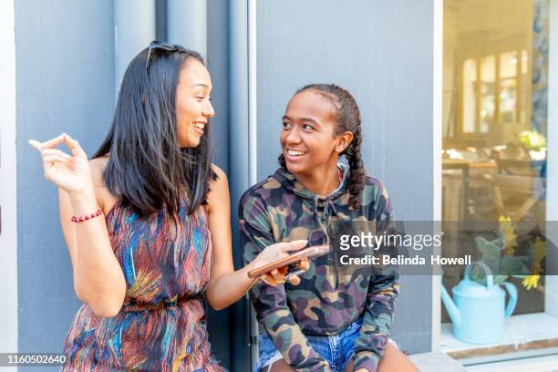 aboriginal australian teenager walking through her city streets, with her mother, posing. - the face of australia photo call stock-fotos und bilder