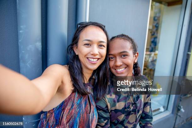 aboriginal australian teenager walking through her city streets, with her mother, posing. - um dia na vida de - fotografias e filmes do acervo
