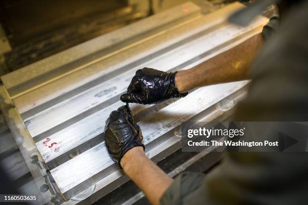 Tom Odom loads stock into a computerized mill to make 1911 fixtures at the Defense Distributed factory in Austin, Texas, on Aug. 5, 2018.