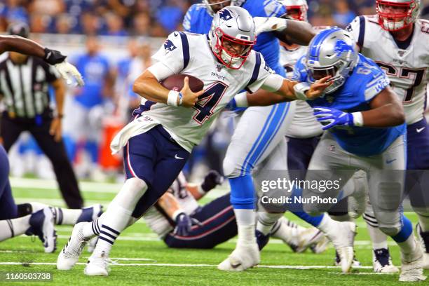 New England Patriots quarterback Jarrett Stidham carries the ball under the pressure of Detroit Lions defensive tackle Fred Jones during the second...