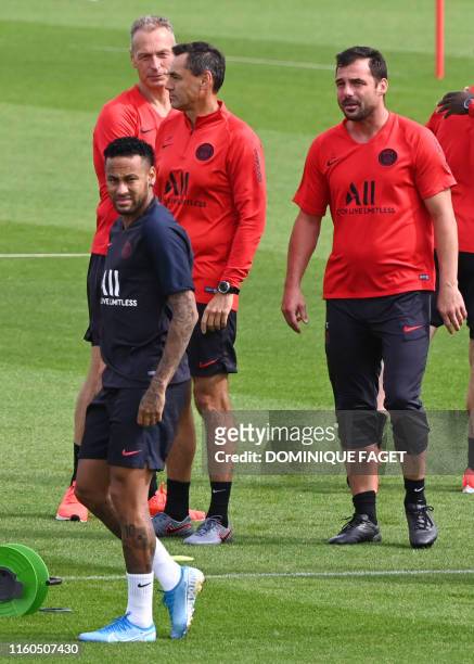 Paris Saint-Germain's Brazilian forward Neymar stands next to assistant coaches Rainer Schrey, Arno Michels and Zsolt Loew as he attends a training...