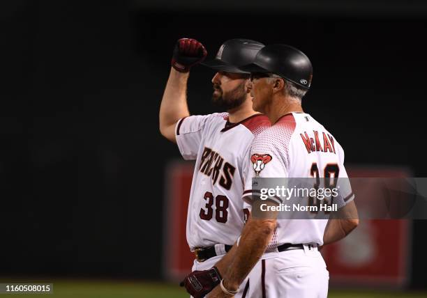 Robbie Ray of the Arizona Diamondbacks gestures to the dugout after hitting an RBI single off of Jon Gray of the Colorado Rockies during the fourth...