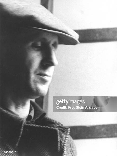 Close-up of German playwright and poet Bertolt Brecht in front of a window, with cap on his head, Paris, France, 1937.