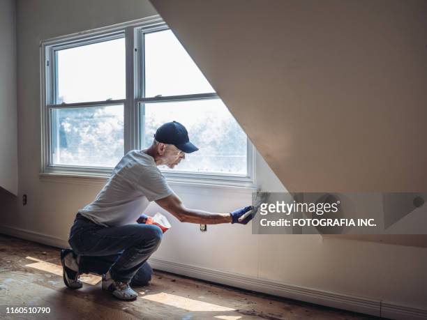 senior man målning lägenhet interiör - renovering bildbanksfoton och bilder