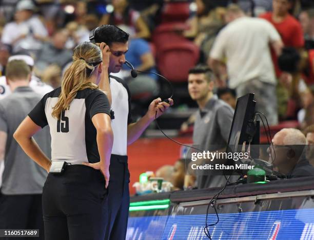 Green lights on the scorer's table are lit indicating a coach's challenge is under way as referees look at video during a game between the Los...