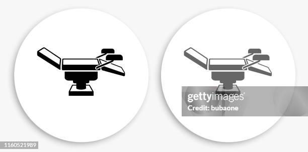examination table black and white round icon - operating table stock illustrations