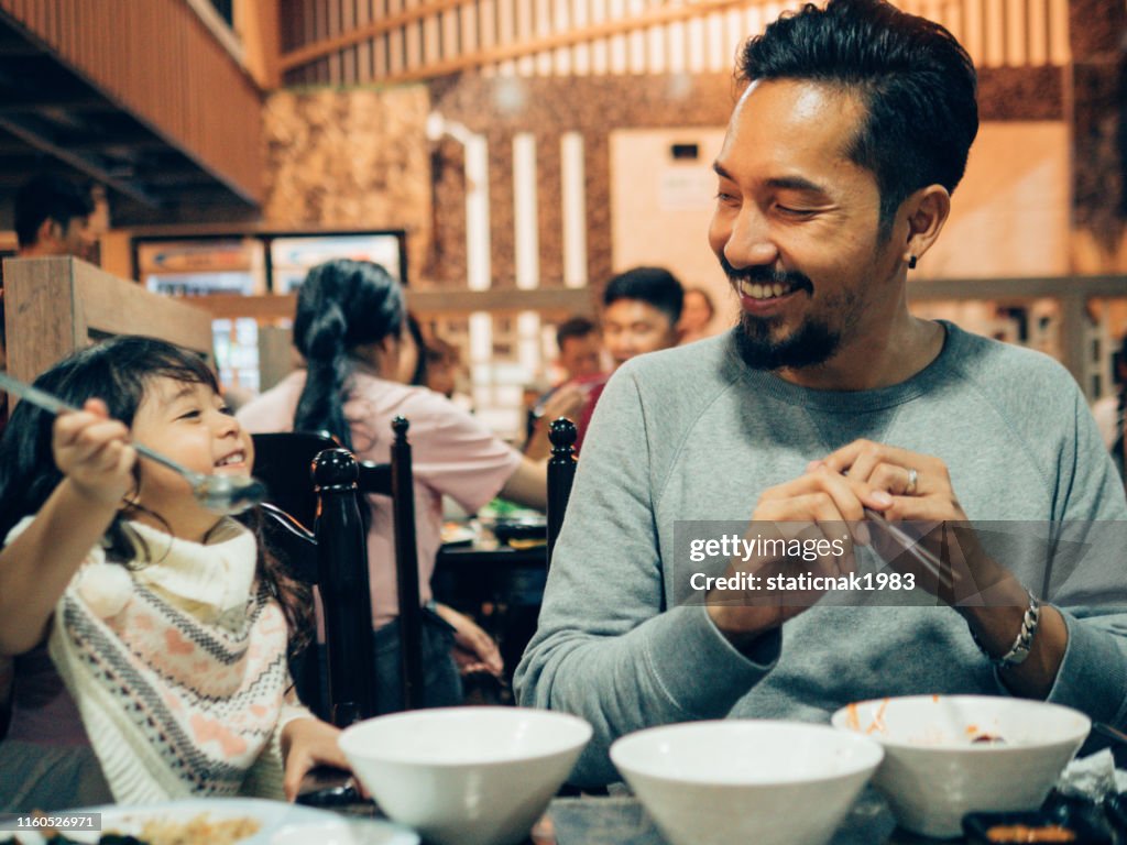 Hipster father and his daughter enjoying in Korea restaurant.