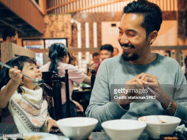 hipster father and his daughter enjoying in korea restaurant. - korean chopsticks stock pictures, royalty-free photos & images