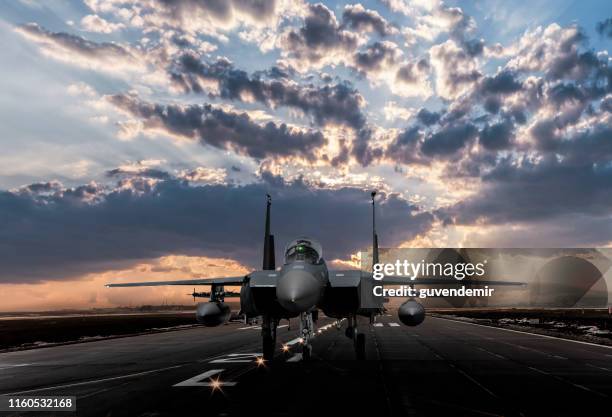 f-15 eagle jet fighter ready to takeoff on runway at sunset - f stop stock pictures, royalty-free photos & images