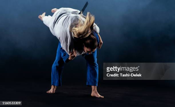 女性柔道家がパートナーを地面に投げ捨てる - judo woman ストックフォトと画像
