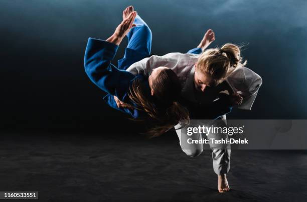 judoka donna gettando il suo partner a terra - arte marziale foto e immagini stock