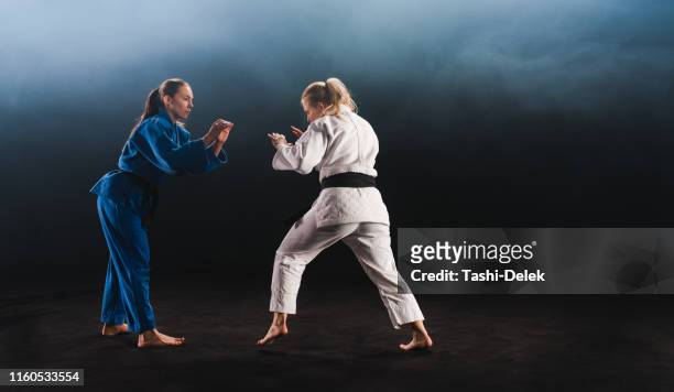 female judo players competing during match - women judo stock pictures, royalty-free photos & images