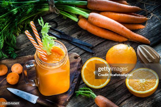 健康的な飲み物:素朴な木製のテーブルにオレンジとニンジンジュース - blended drink ストックフォトと画像