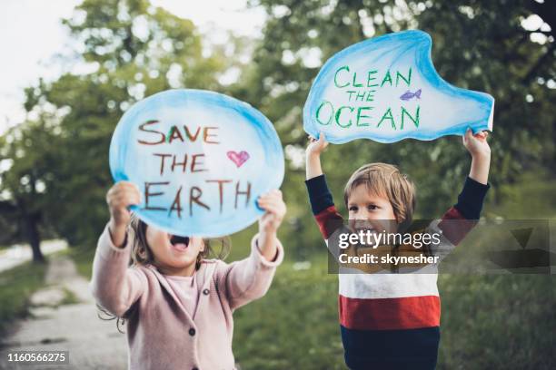 save our childhood by saving the environment! - warming sign stock pictures, royalty-free photos & images