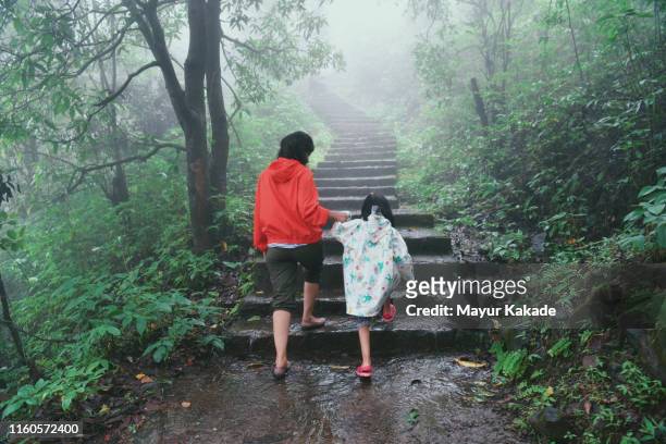 mother and daughter hiking the stairs during monsoon season - enjoy monsoon stock-fotos und bilder