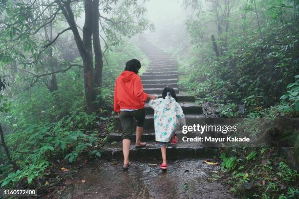 mother and daughter hiking the stairs during monsoon season - enjoy monsoon photos et images de collection