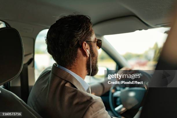 businessman using headphones in the car - car listening to music imagens e fotografias de stock