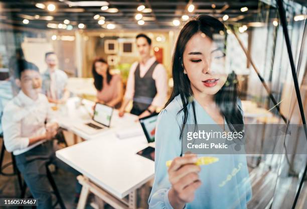 asiatische geschäftsfrau präsentiert ihre ideen für die unternehmensentwicklung - entwicklung stock-fotos und bilder