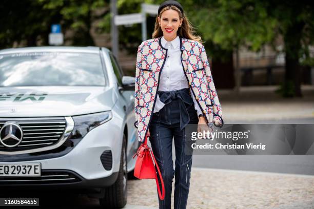 Alexandra Lapp is seen in front of her personalized Mercedes Benz EQC, wearing a white Gucci Sylvie tweed jacket, a white Talbot Runhof cape blouse,...