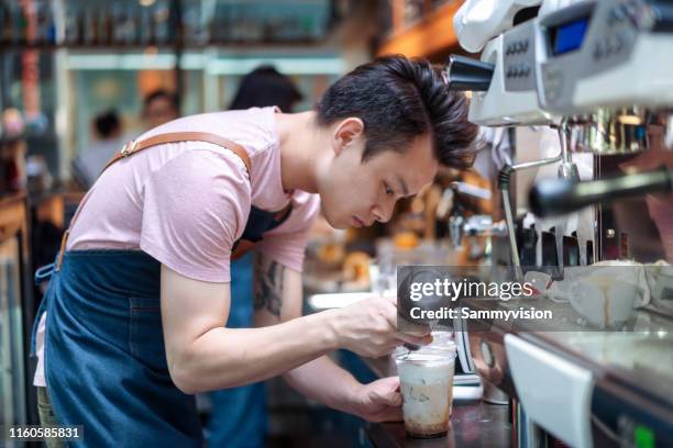 asian barista making coffee in the cafe - barista coffee restaurant stockfoto's en -beelden