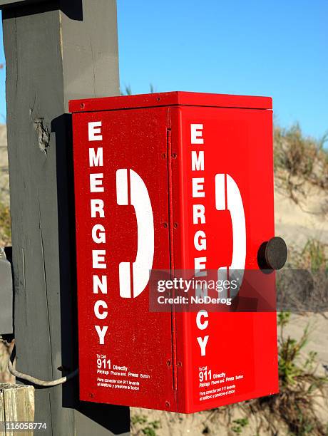 red emergency telephone box on beach. - emergency telephone box stock pictures, royalty-free photos & images