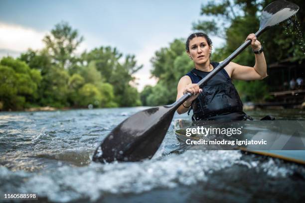 leidenschaftliche athletin im kajak - wildwasser fluss stock-fotos und bilder