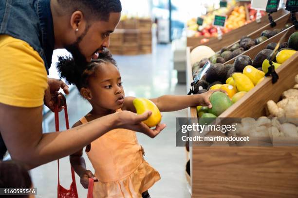 father and daughter in zero waste oriented fruit and grocery store. - haitian ethnicity stock pictures, royalty-free photos & images