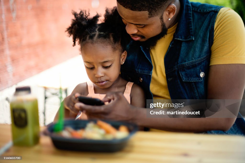 Vater und Tochter essen essen essen essen im Freien Essen.