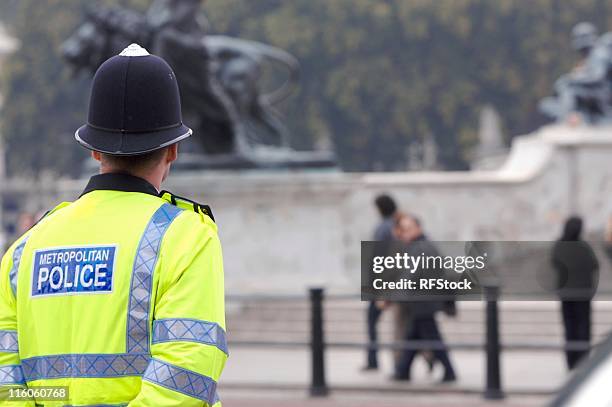 a british cop standing guard at buckingham palace - politiedienst stockfoto's en -beelden