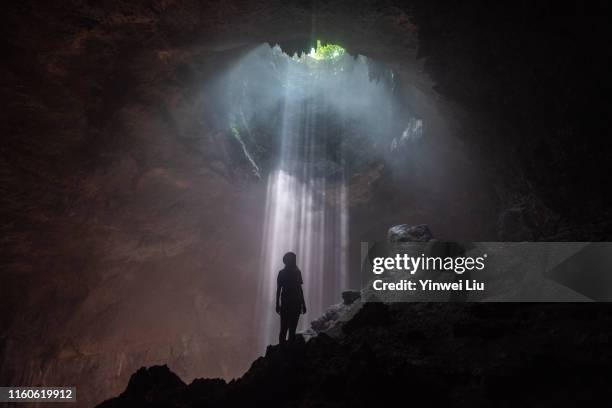 the light falling down in jomblang cave - aushöhlung stock-fotos und bilder