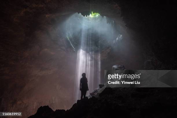 the light falling down in jomblang cave - cave foto e immagini stock