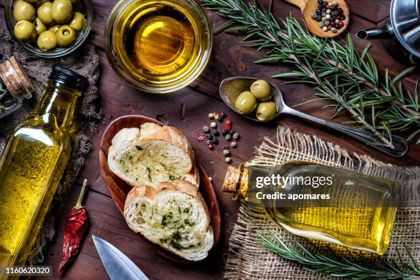 snack oder vorspeise aus knoblauch-basilikum und olivenöl bruschetta auf dem tisch in einer rustikalen küche - mediterranes essen stock-fotos und bilder