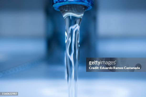 water coming out of a tap - grondstoffen stockfoto's en -beelden