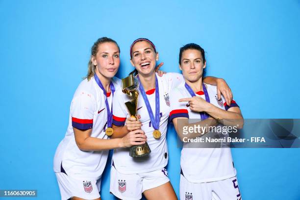 Allie Long, Alex Morgan and Kelley O'Hara of the USA poses with the Women's World Cup trophy after the 2019 FIFA Women's World Cup France Final match...