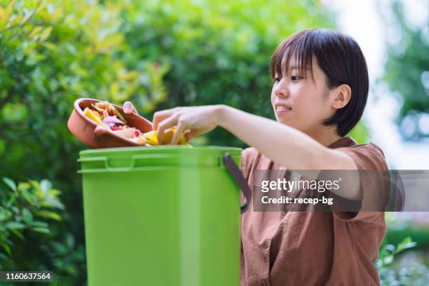 mujer poniendo basura de comida en compostador - daily bucket fotografías e imágenes de stock