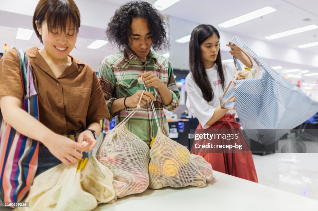 Friends doing shopping at supermarket with their reusable shopping bag