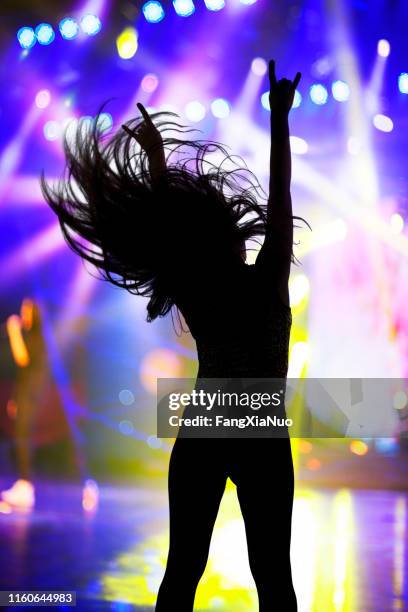 jeune femme dansant avec des bras soulevés au festival de musique - women dancing on music cutout photos et images de collection