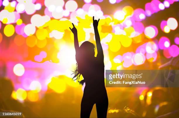 frau tanzt mit erhobenen händen bei nachtclubkonzert - pop music stock-fotos und bilder