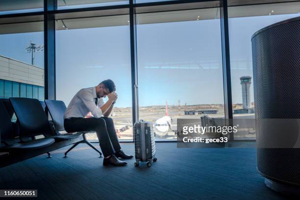 unhappy passenger waits for flight at airport - pressure airplane stock pictures, royalty-free photos & images