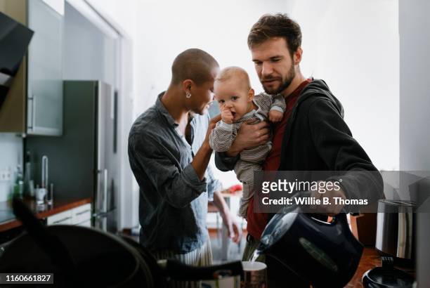 gay father multitasking with baby - busy lifestyle stockfoto's en -beelden