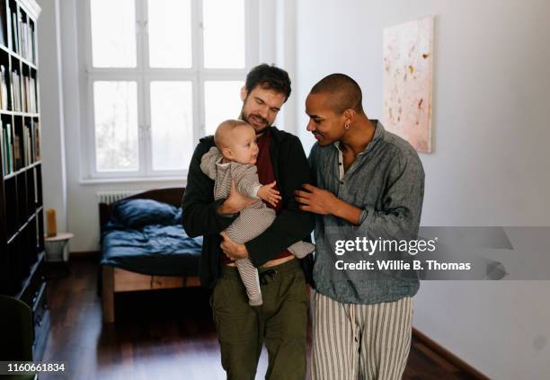 gay fathers leaving bedroom with son - baby family stockfoto's en -beelden