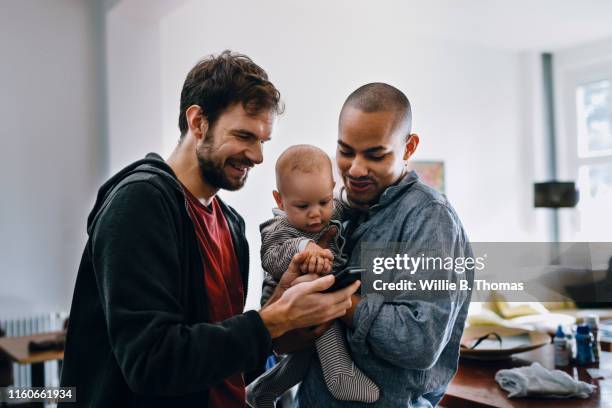 gay couple with their baby - baby group stock-fotos und bilder