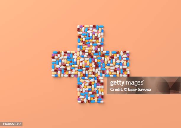 cross shaped pills and capsules - red cross stock pictures, royalty-free photos & images