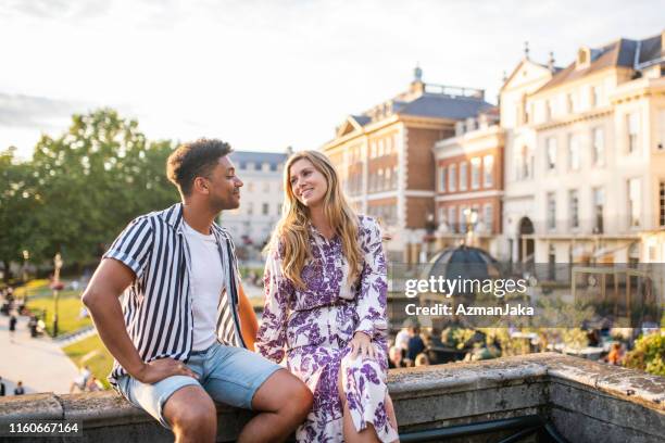 happy mid adult paar zittend op richmond bridge bij zonsondergang - couple london stockfoto's en -beelden