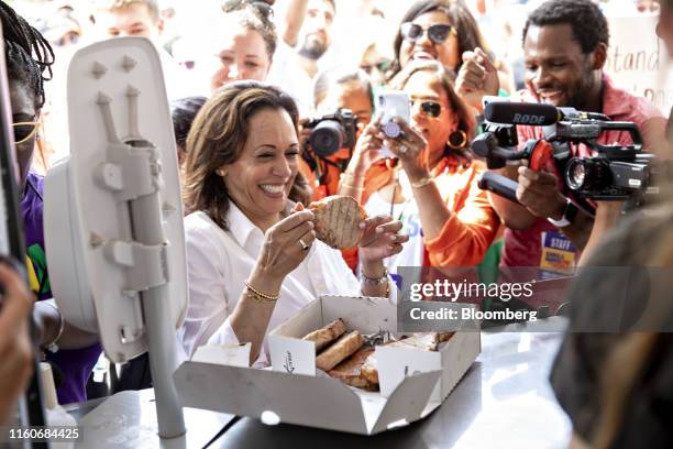 Senator Kamala Harris, a Democrat from California and 2020 presidential candidate, center, holds a pork chop as during the Iowa State Fair in Des...