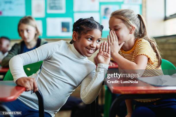 psst... ik weet het antwoord - child whispering stockfoto's en -beelden