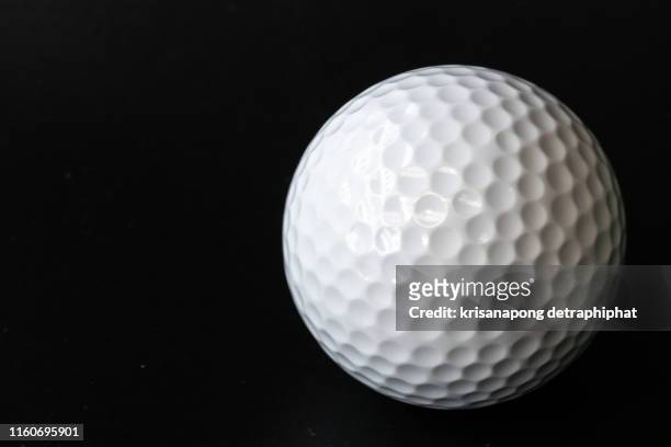 golf ball on a black background - ゴルフボール ストックフォトと画像