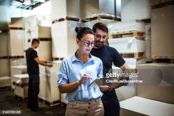 warehouse supervisor walking and talking with senior manager - consumerism stock pictures, royalty-free photos & images