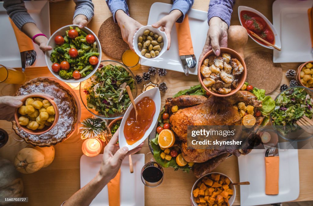 Above view of passing food during Thanksgiving dinner.